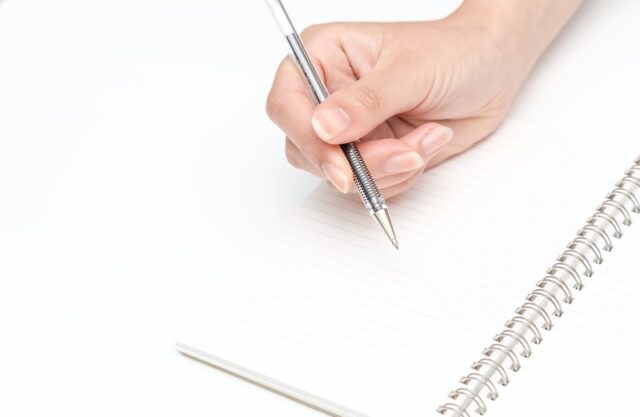 ペンを握る手とノート